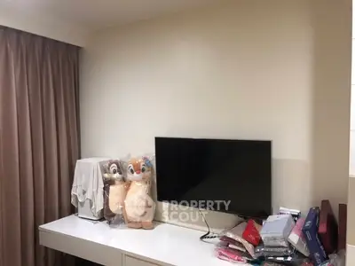 Cozy bedroom corner with TV and plush toys on a sleek white dresser, perfect for relaxation.