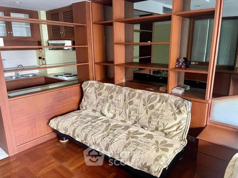 Cozy living room with wooden shelving and compact kitchen area