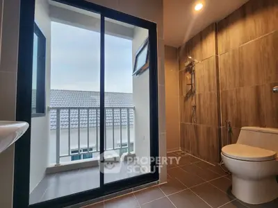 Modern bathroom with balcony view and sleek shower design.