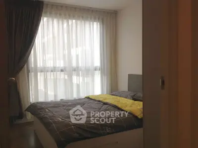 Cozy bedroom with large window and modern decor in a stylish apartment.
