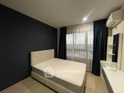 Modern bedroom with stylish dark accent wall and large window view.