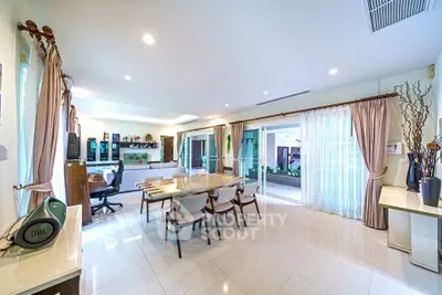 Spacious open-plan living and dining area with modern decor and large windows for natural light.