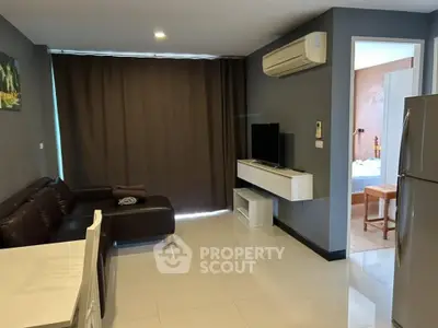 Modern living room with sleek furniture and open layout, featuring a cozy sofa and wall-mounted TV.