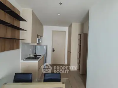 Modern kitchen with sleek cabinetry and dining area in a stylish apartment.