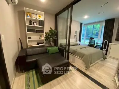 Modern studio apartment with glass partition, cozy living area, and scenic window view.