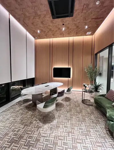 Modern living room with stylish decor, featuring a marble table, unique chairs, and elegant lighting.