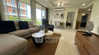 Spacious modern living room with elegant decor and large windows offering natural light.