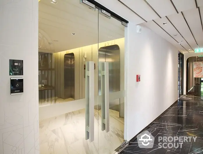 Modern building entrance with sleek glass doors and marble flooring