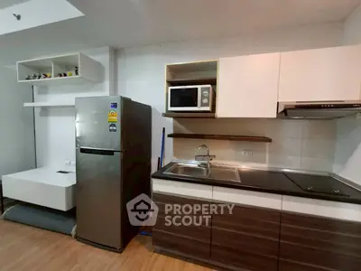 Modern kitchen with stainless steel fridge and microwave in sleek apartment