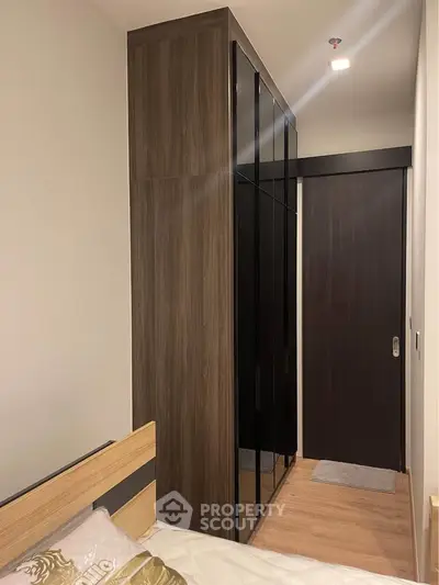 Modern bedroom with sleek wooden wardrobe and cozy bed setup