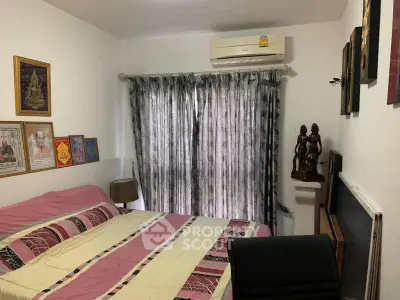Cozy bedroom with air conditioning and decorative art, featuring a comfortable bed and elegant curtains.