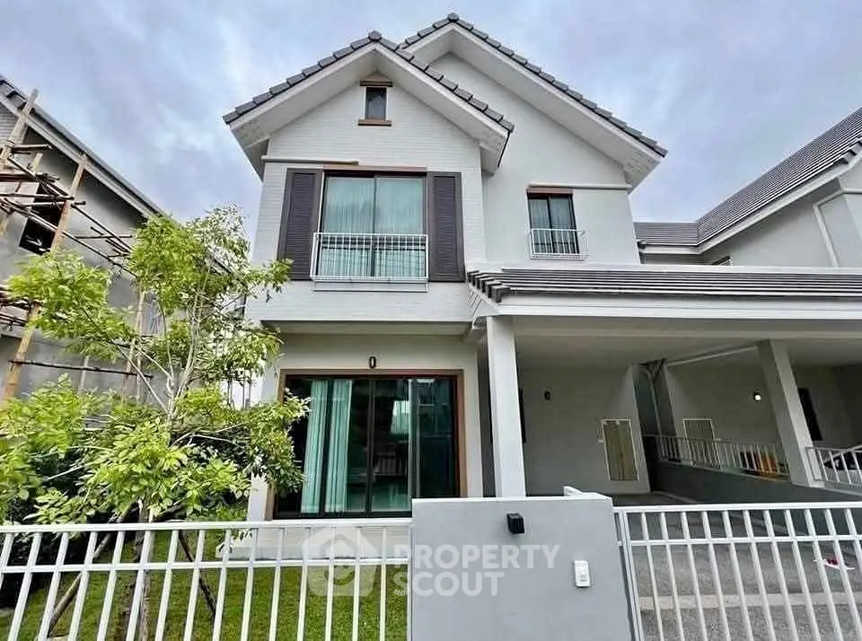 Modern two-story house with spacious driveway and lush greenery