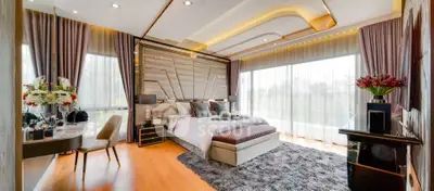Luxurious bedroom with elegant decor and large windows offering natural light.