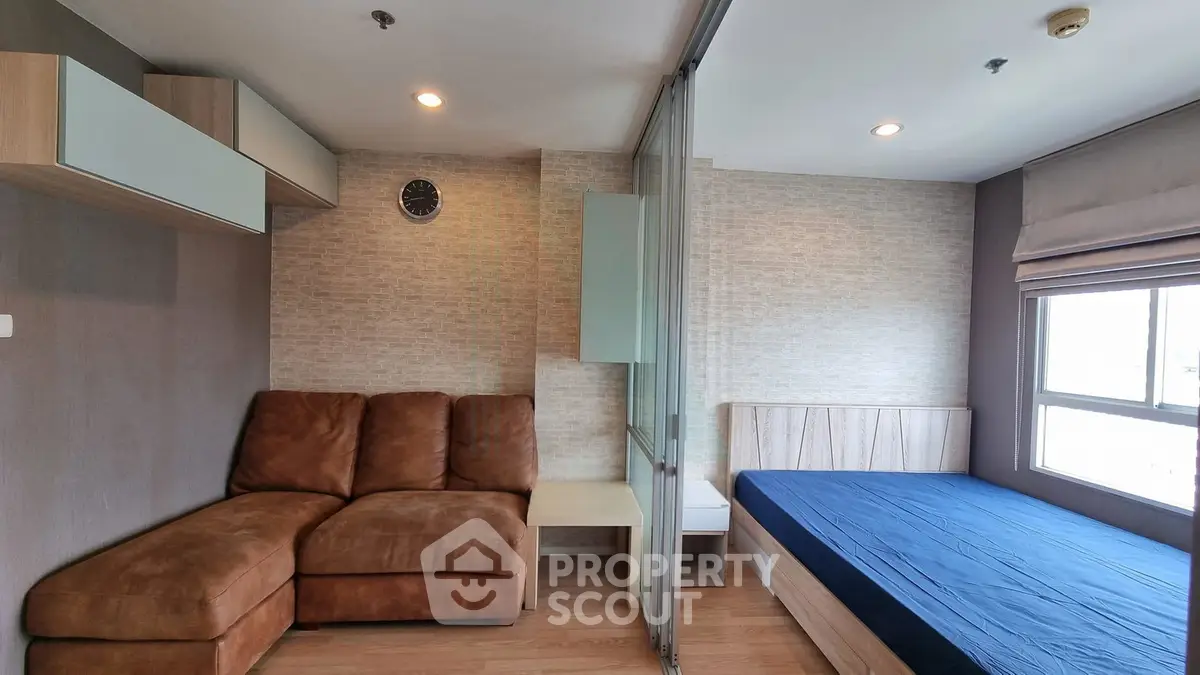 Modern studio apartment with cozy living area and bed, featuring stylish decor and ample natural light.