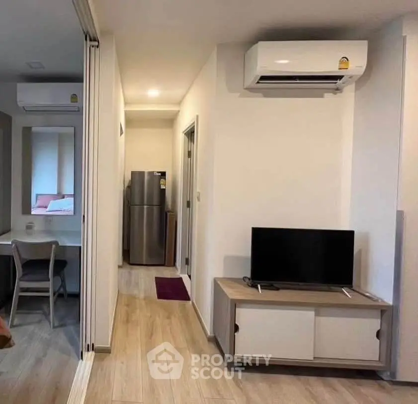 Modern apartment interior with air conditioning and sleek furniture, featuring a compact living area and kitchen.