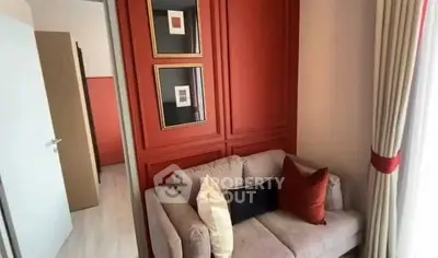 Cozy living room with stylish red accent wall and comfortable sofa, perfect for relaxation.