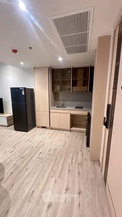 Modern kitchen with sleek cabinetry and spacious layout, featuring a black refrigerator and built-in appliances.