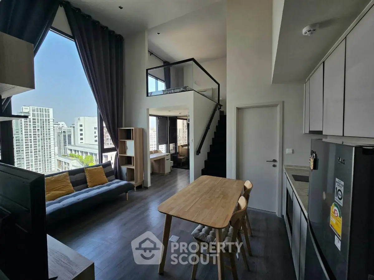 Modern loft apartment with high ceilings and city view, featuring open living area and stylish kitchen.