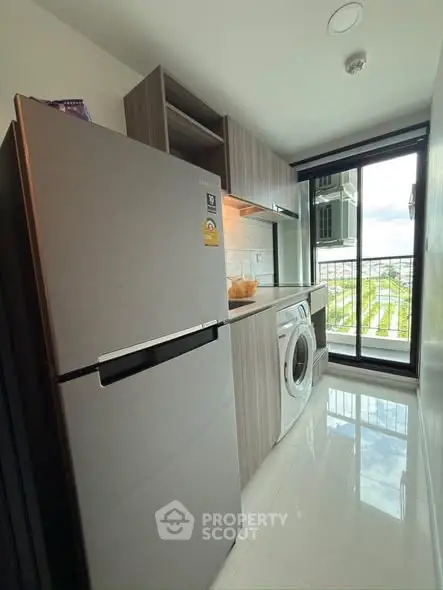 Modern kitchen with sleek appliances and balcony view in a stylish apartment.