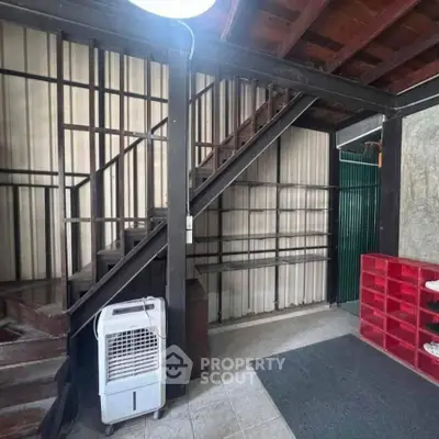 Industrial-style interior with wooden staircase and metal shelving, perfect for creative loft living.