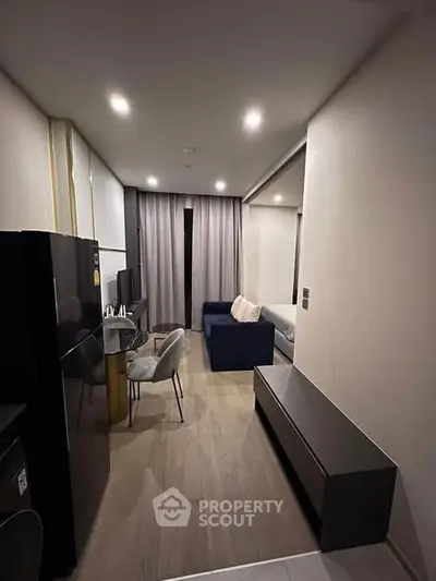 Modern apartment interior with sleek kitchen and cozy living area, featuring stylish furniture and ambient lighting.