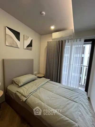 Cozy bedroom with modern decor and balcony view in a stylish apartment.