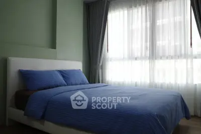 Cozy bedroom with large window and blue bedding in modern apartment