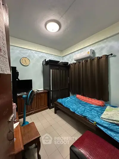 Cozy bedroom with air conditioning, wardrobe, and TV, ideal for comfortable living.