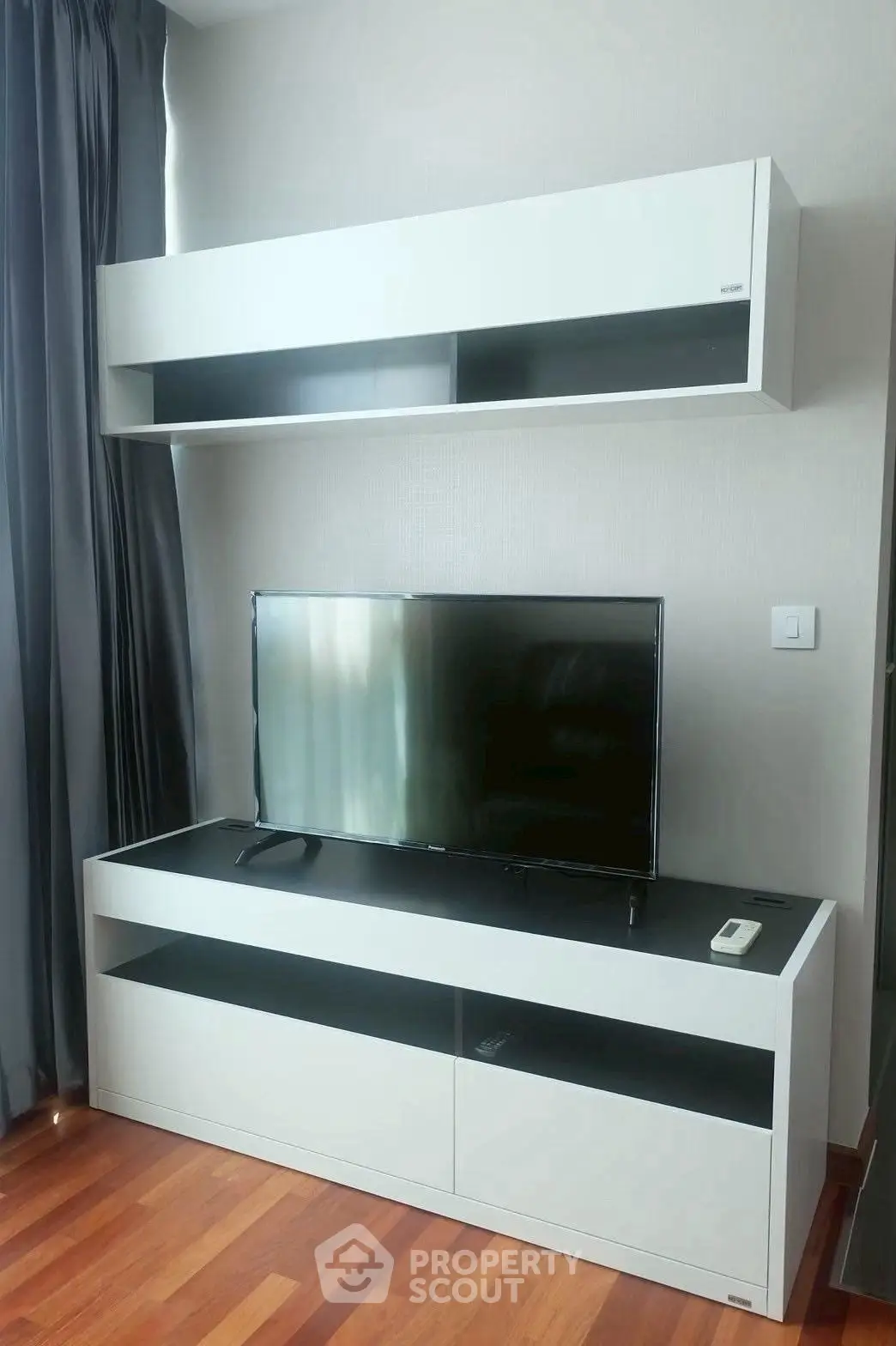 Modern living room with sleek TV unit and wooden flooring