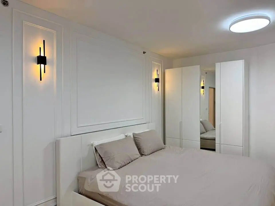 Modern bedroom with elegant lighting and sleek white furniture