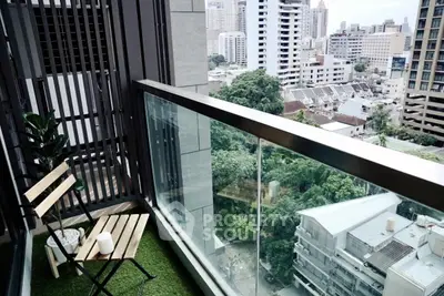 Modern balcony with city view, featuring glass railing and cozy seating area, perfect for urban living.