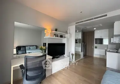 Modern studio apartment with open layout, featuring a cozy living area and sleek kitchen design.
