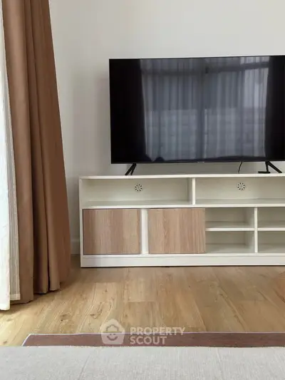 Modern living room with sleek TV stand and large flat-screen TV