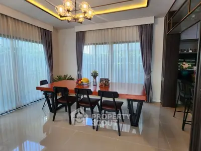 Elegant dining room with modern chandelier and large windows for natural light.