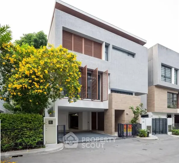 Modern three-story townhouse with sleek design and lush landscaping
