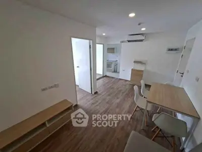Modern apartment with open layout, featuring sleek wooden flooring and minimalist furniture design.
