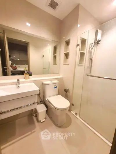 Modern bathroom with glass shower and sleek fixtures in a contemporary apartment.