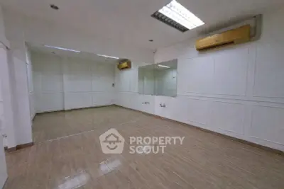 Spacious room with mirrored wall and wooden flooring, ideal for dance or fitness studio.