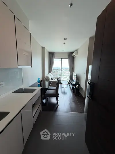 Modern open-layout kitchen and living room with large window and scenic view.