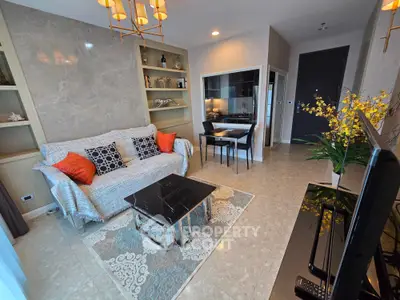 Elegant living room with modern decor, marble accents, and cozy seating in a stylish apartment.