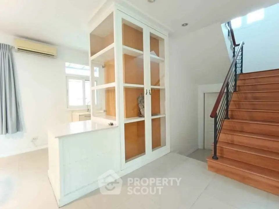 Spacious interior with modern staircase and built-in storage unit, perfect for stylish living.