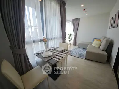 Modern living room with elegant dining setup and large windows