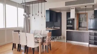 Modern open-plan kitchen and dining area with elegant lighting and sleek design.