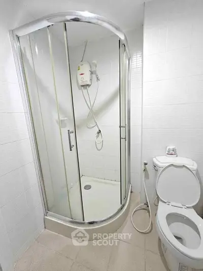 Modern bathroom with glass shower enclosure and white fixtures.