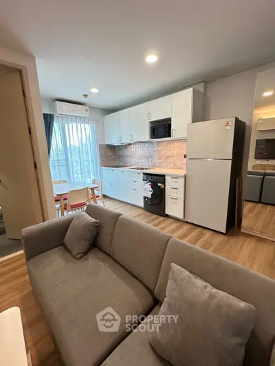 Modern open-plan living room and kitchen with sleek design and natural light