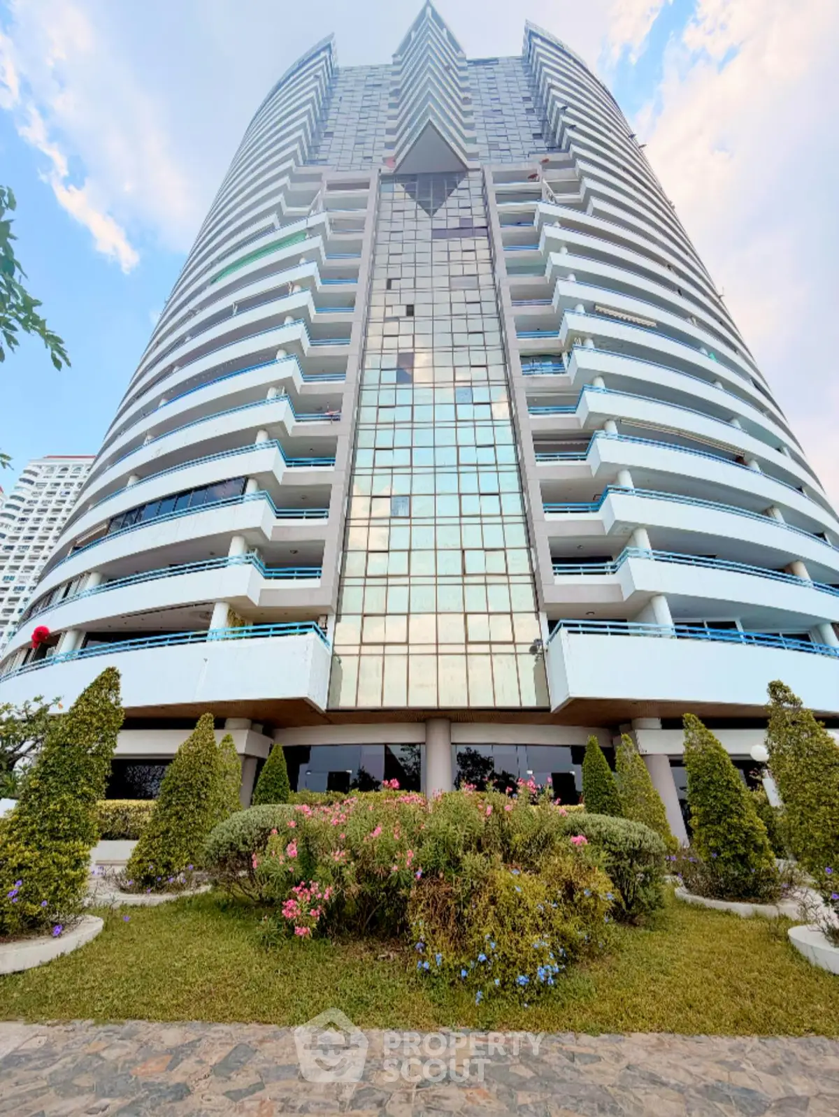 Stunning high-rise building with modern architecture and lush landscaping, perfect for urban living.