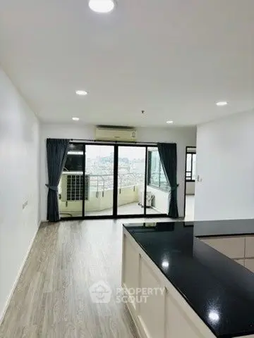 Spacious open-plan living area with balcony and city view