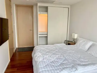 Modern bedroom with sleek design and wooden flooring in a stylish apartment.