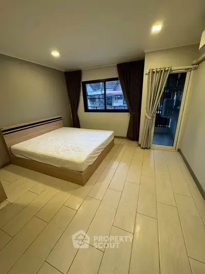 Spacious bedroom with large windows and modern design in a stylish apartment.