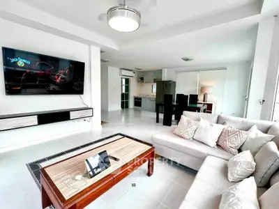 Spacious modern living room with sleek furniture and open kitchen layout
